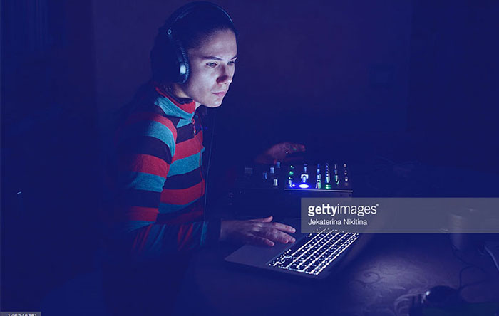 دختری که به وسیله لپ‌تاپ به ویرایش موسیقی مشغول است