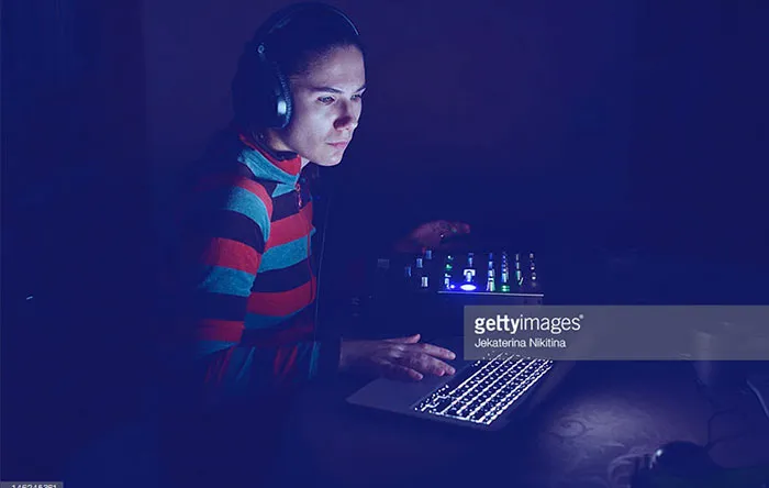 دختری که به وسیله لپ‌تاپ به ویرایش موسیقی مشغول است