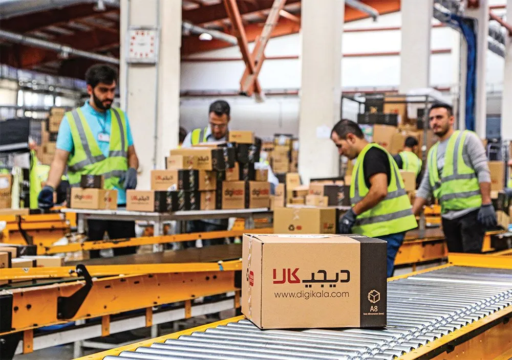 یکی از کارکنان مرکز پردازش دانش در حال برداشتن محصولات دیجی کالا