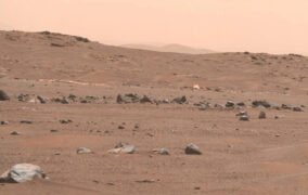 چتر نجات مریخ‌نورد افتاده روی سطح مریخ در سمت چپ تصویر دیده می‌شود و سمت راست آن سپر محافظ قرار گرفته است.