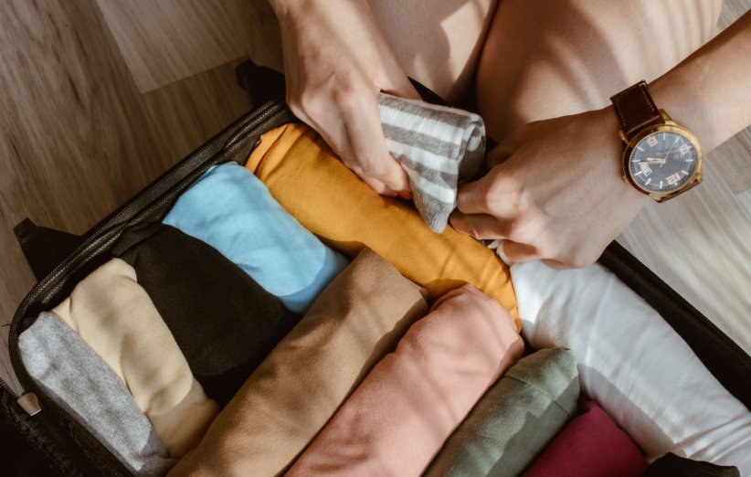 رول کردن لباس‌ها برای چمدان مسافرت