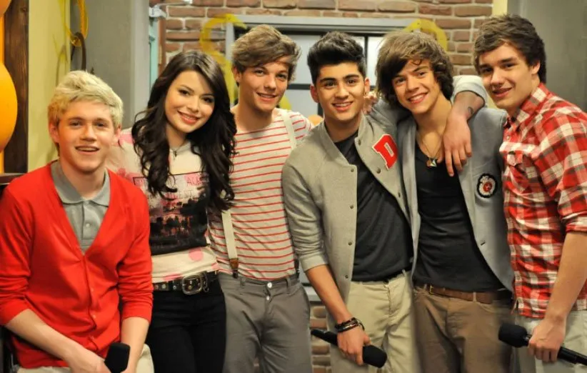 از راست، لیام پین، هری استایلز، زین مالیک، لوئیس تاملینسون، میراندا کاسگروو و نیال هوران در نمایی از سریال آی کارلی