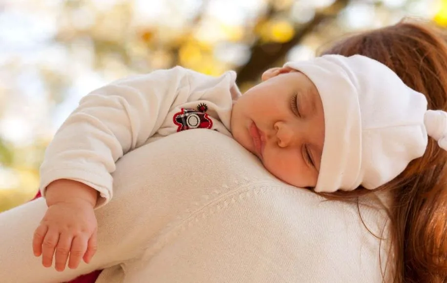 کودکی روی شانه مادر خواب است.