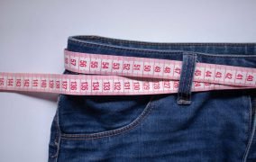 یک شلوار جین که در آن از یک متر به جای کمربند استفاده شده است