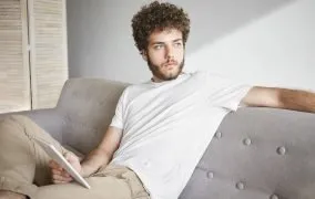 مردی با لباسی راحت روی مبل