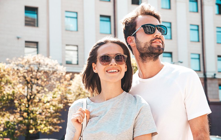 یک زوج جوان در فضای بیرونی با تی‌شرت و عینک آفتابی