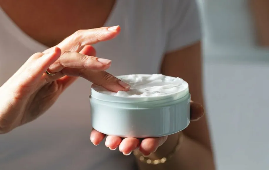 شخصی که یک قوطی کرم در دست دارد