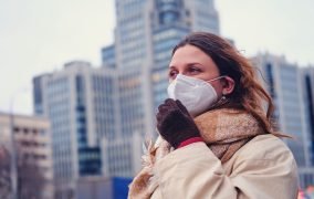 زنی که در هوایی آلوده از ماسک استفاده می‌کند.