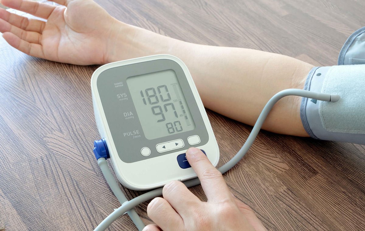 فردی که با فشارسنج خانگی فشار خون خود را اندازه می‌گیرد