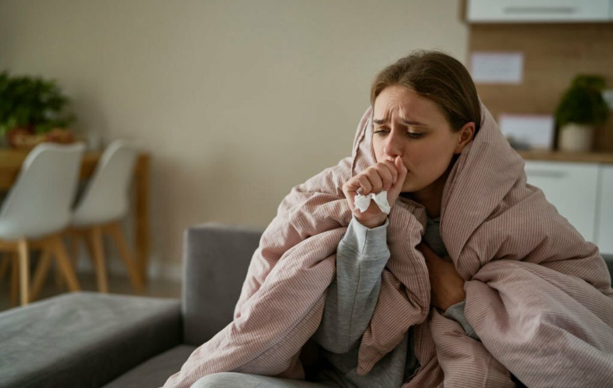 یک زن مبتلا به سرماخوردگی که سرفه می‌کند