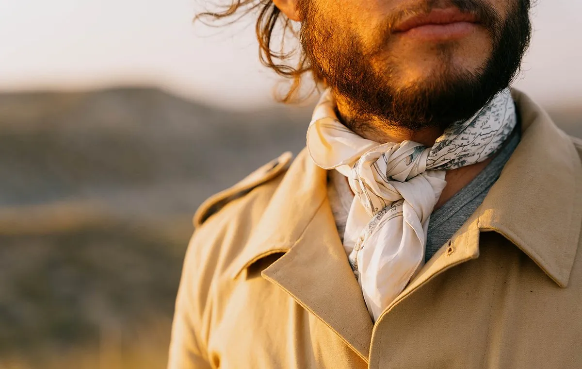 مردی با کت سافاری و دستمال گردن