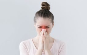 خانمی که بینی خود را به دلیل درد سینوزت گرفته است.