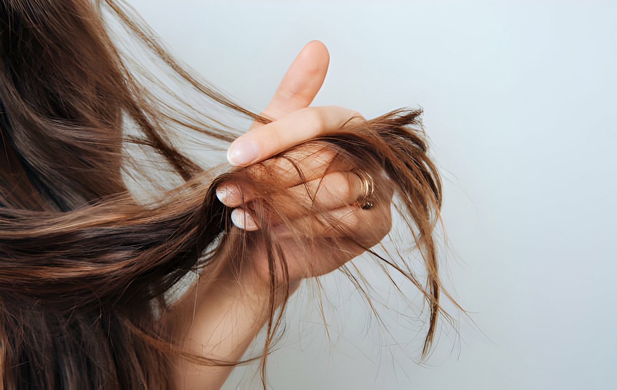 یک زن که بخشی از موهای خود را به انگشت‌هایش گرفته است