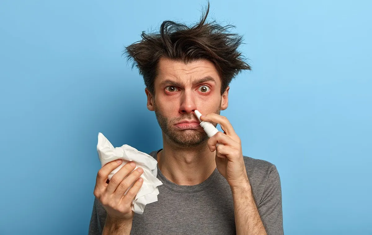 یک مرد دارای آلرژی در حال استفاده از قطره‌چکان