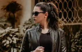 زن جوانی با کت چرم و عینک آفتابی