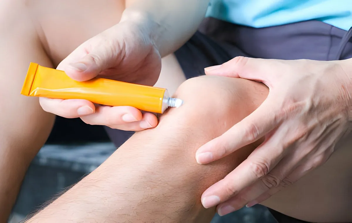 فردی که روی زانوی خود پماد ضد درد می‌زند