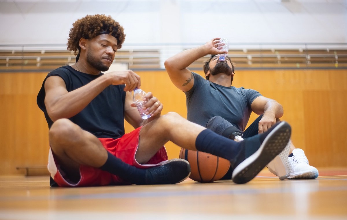 دو مرد ورزشکار در تصویر با بطری های مایعات ایزوتونیک هستند
