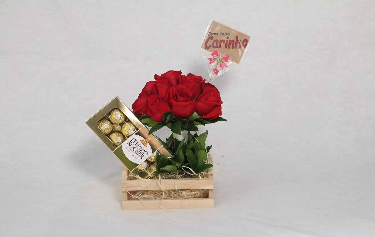 یک بسته شکلات ولنتاین و یک دسته گل رز قرمز در تصویر است