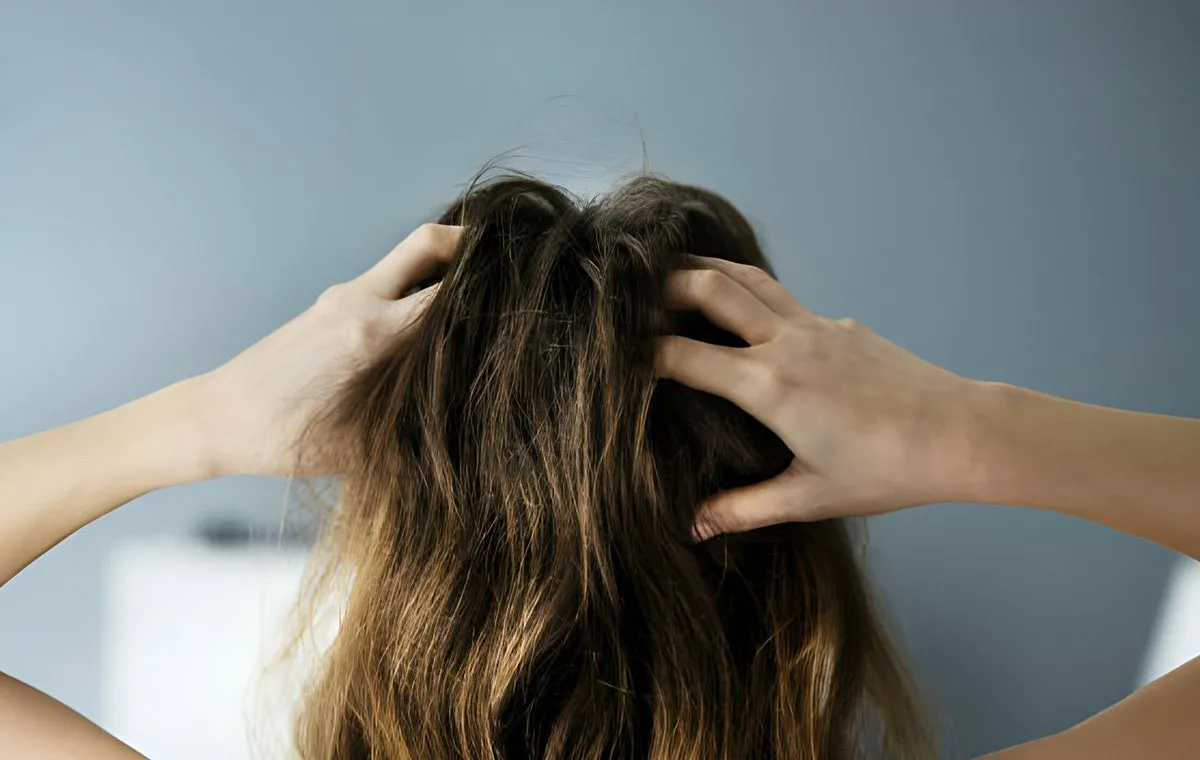 یک زن پوست سر خود را ماساژ می‌دهد