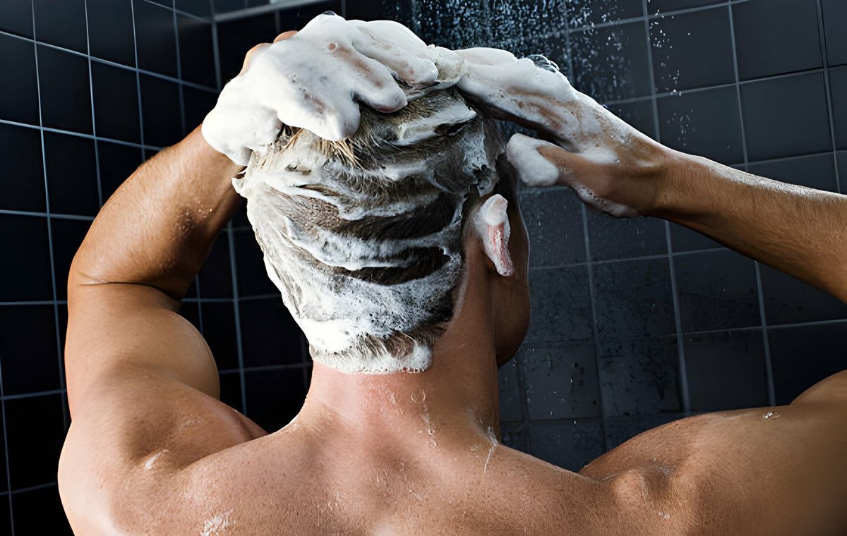 یک مرد که موهای خود را با شامپو می‌شوید