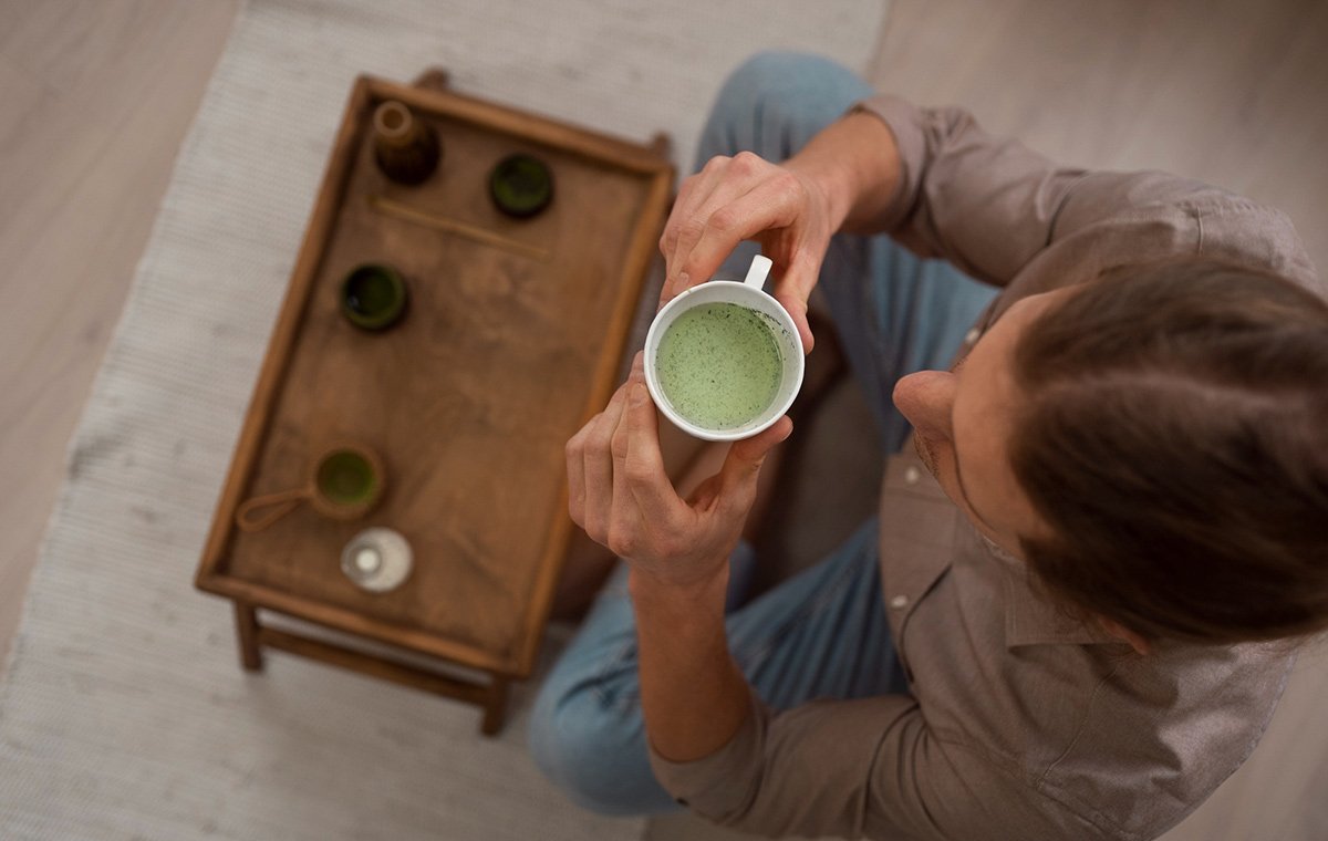 یک مرد در حال نوشیدن یک لیوان از چای ماچا