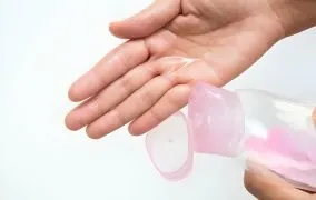 شخصی که روغن بچه را روی کف دست خود ریخته است