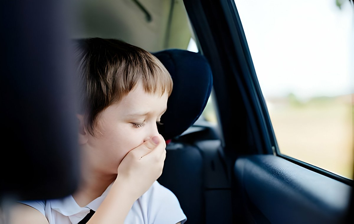 یک پسربچه داخل ماشین که با دست جلوی دهان و بینی خود را گرفته است