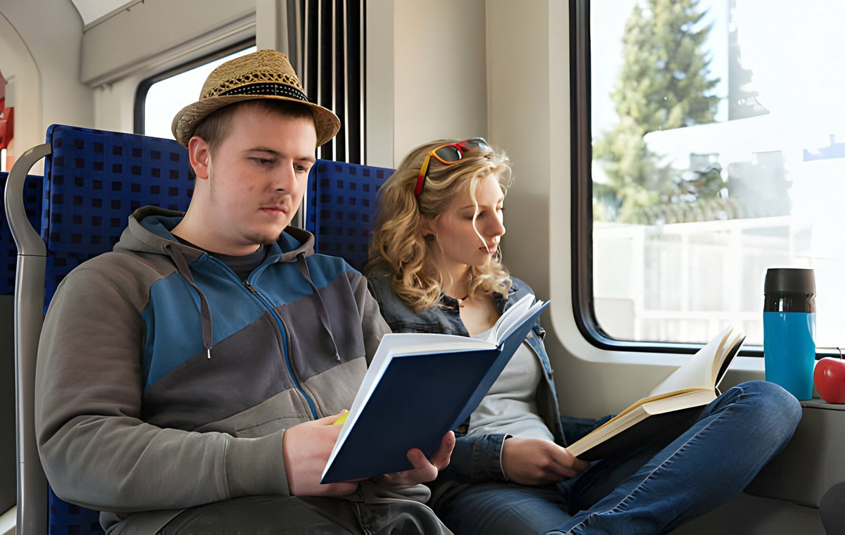 یک زن و مرد جوان که داخل قطار کتاب می‌خوانند