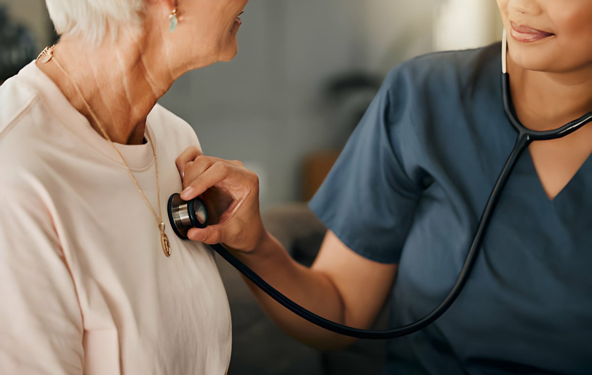 یک پزشک که گوشی پزشکی را روی قلب یک زن سالمند قرار داده است