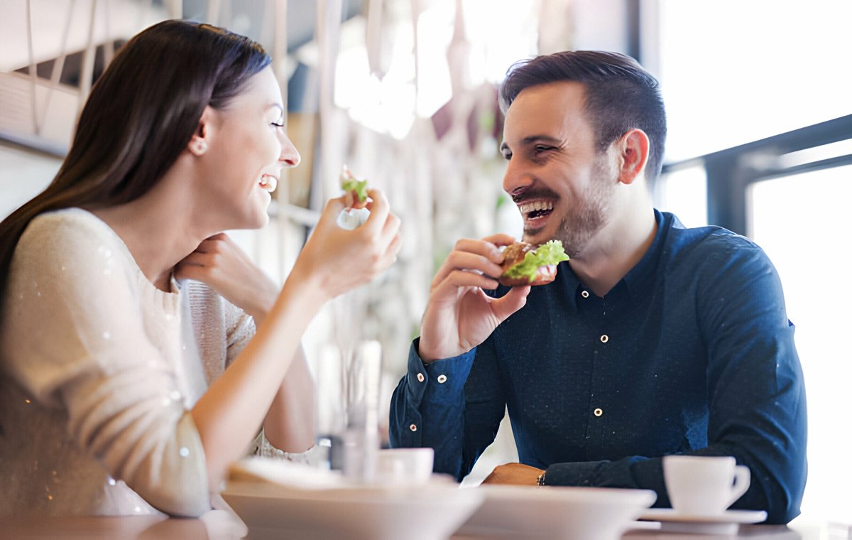 یک زن و مرد جوان که در رستوران غذا می‌خورند