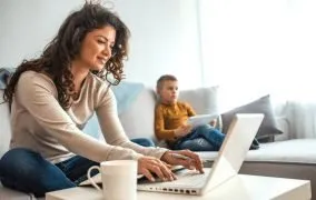 یک زن خانه‌دار با لپ‌تاپ کار می‌کند.