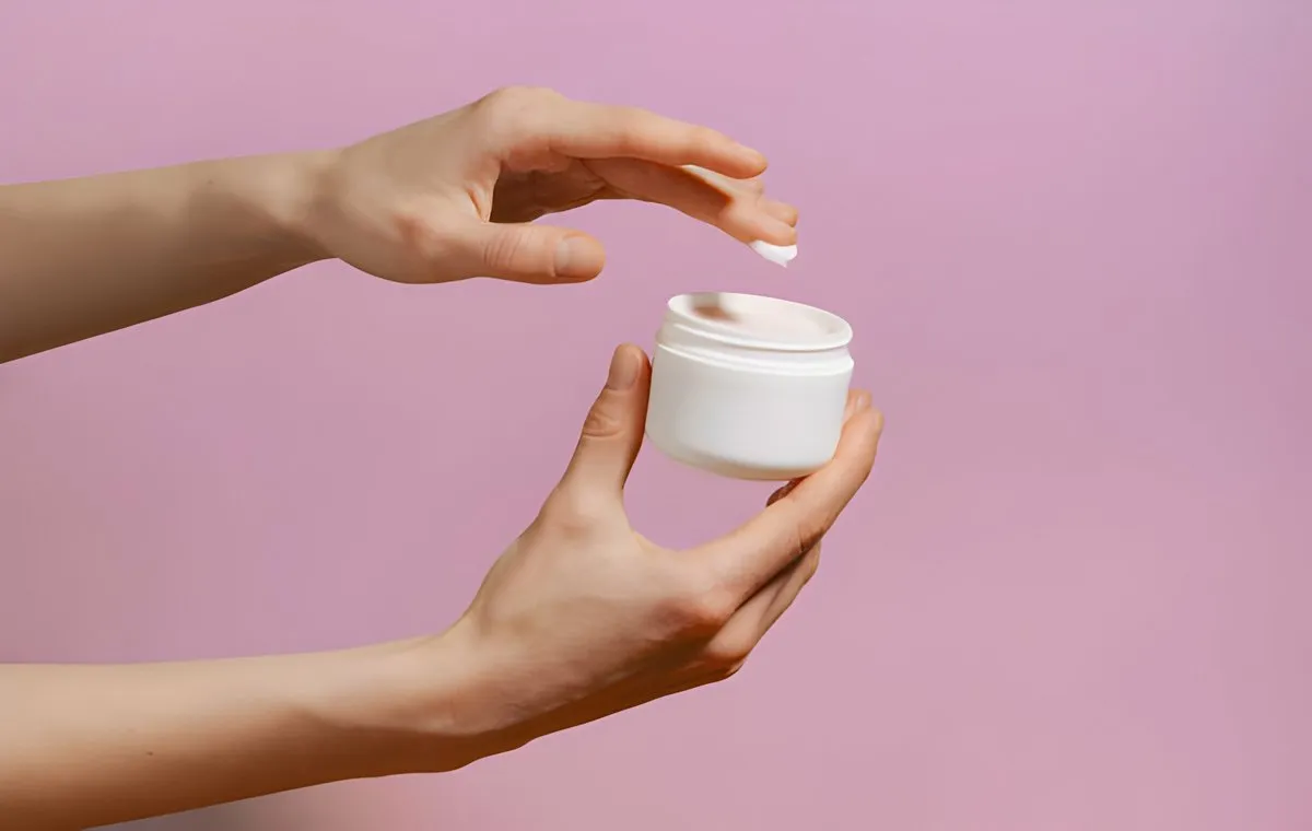 یک زن مقداری کرم از داخل قوطی برمی‌دارد