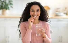 یک زن جوان که مکمل آهن می‌خورد