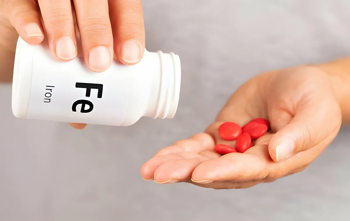 فردی که مکمل آهن را از داخل قوطی روی کف دست خود ریخته است