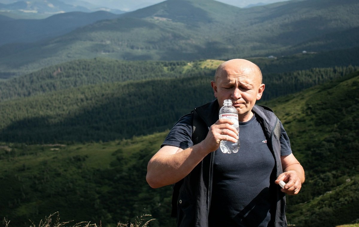 یک اقا در حال خوردن آب برای هیدراته ماندن و کاهش وزن میانسالی است