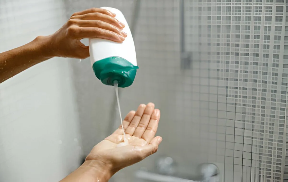 یک نفر شامپو را کف دست خود می‌ریزد