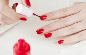 زنی در حال لاک زدن دست مخالف