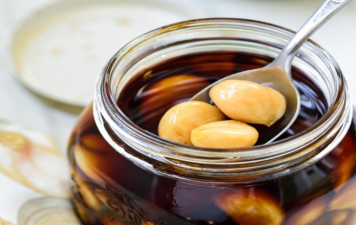 یک شیشه سیر ترشی خانگی چند ساله با بوی خوب و خوش طعم در تصویر است
