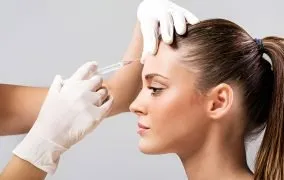 پزشک بوتاکس را به پیشانی زن تزریق می‌کند