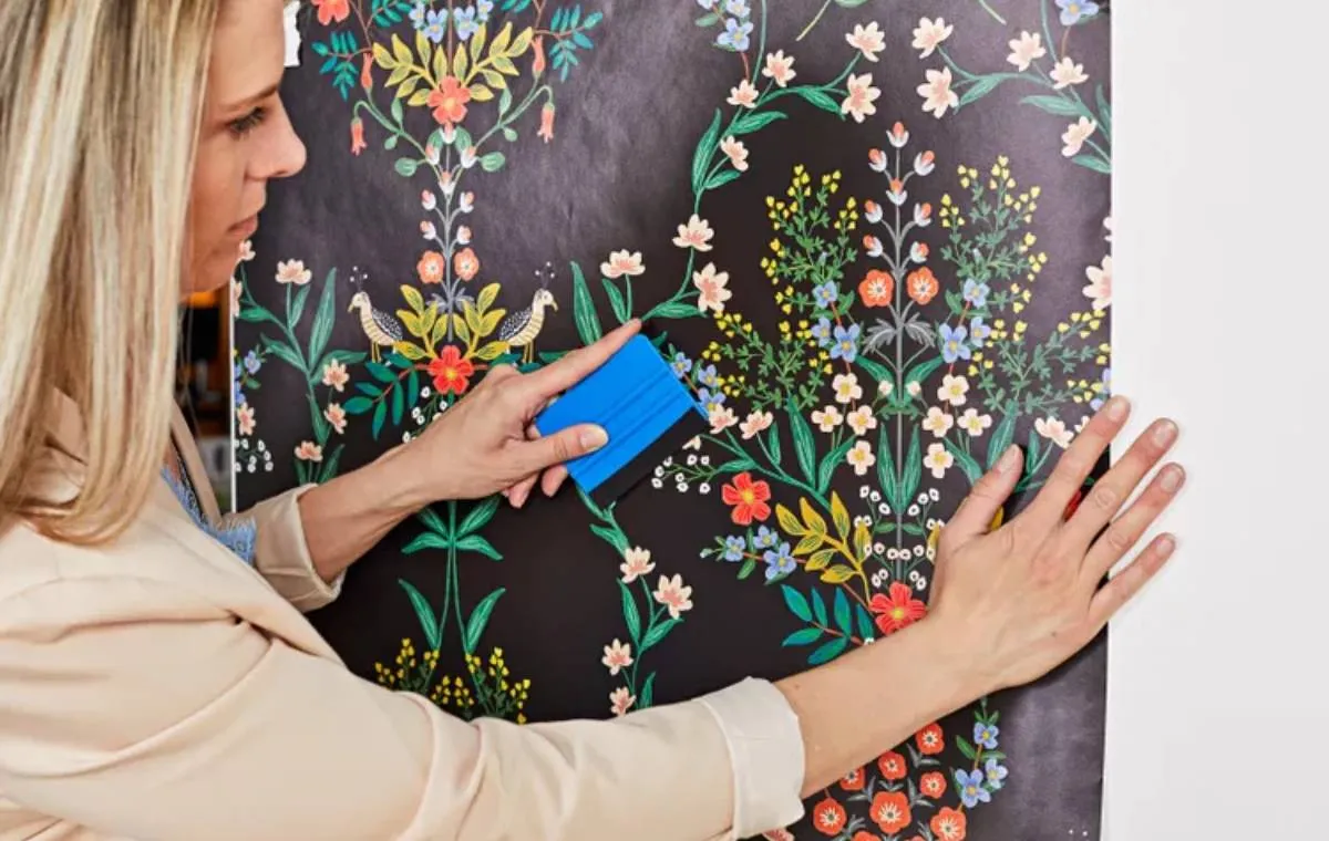 زنی در حال نصب کاغذ دیواری موقت