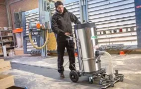 یک مرد در حال استفاده از جاروبرقی صنعتی