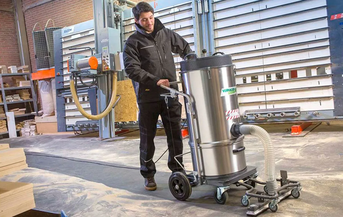 یک مرد در حال استفاده از جاروبرقی صنعتی