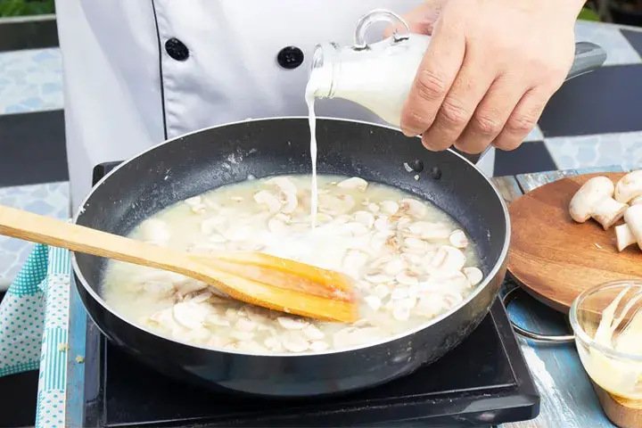 اضافه کردن شیر به سوپ قارچ در صورت غلیظ شدن سوپ