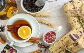 لیوان دمنوش گیاهی گرم با عسل و لیمو برای درمان زخم معده.